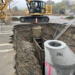 Trench box in trench with ladder for safe entry and excavator parked up top, danvers MA